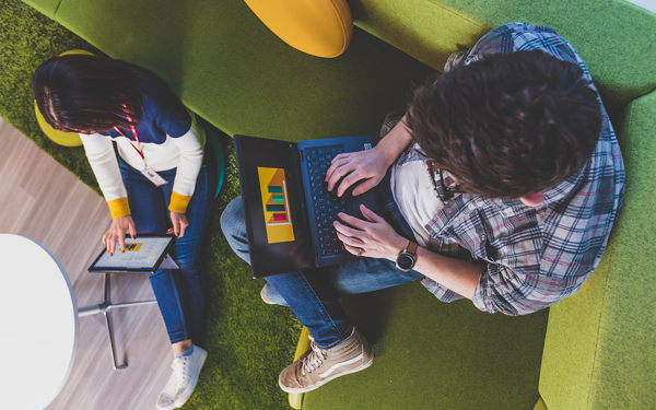 Two team members working on laptops